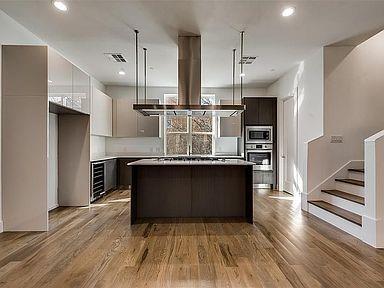a kitchen with kitchen island stainless steel appliances a refrigerator and a stove top oven