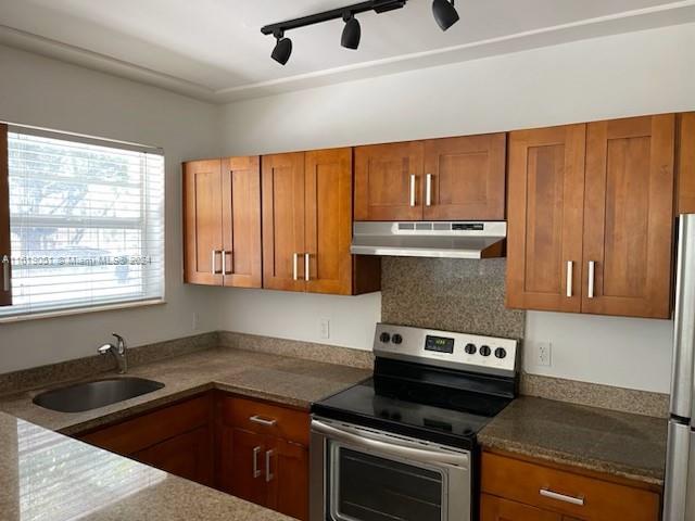 a kitchen with a sink a stove cabinets and a window