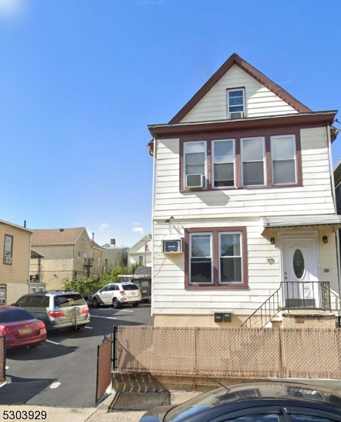 a front view of a house with a cars parked