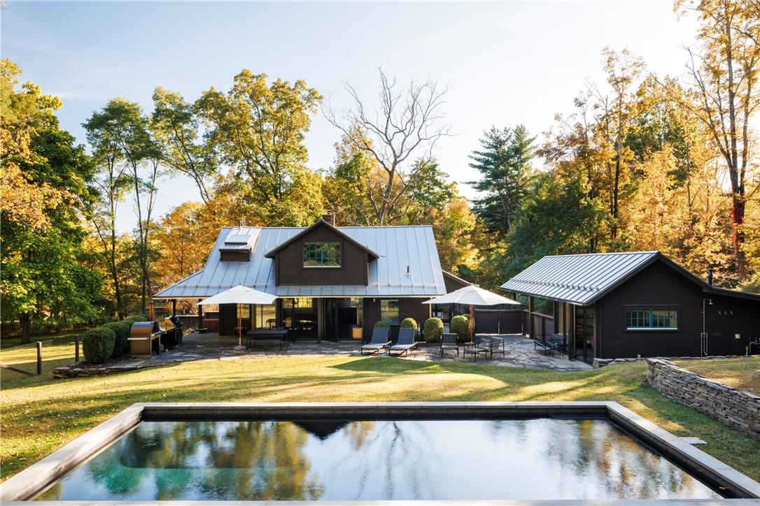 Rear view of house with a pool, patio,  and a lawn