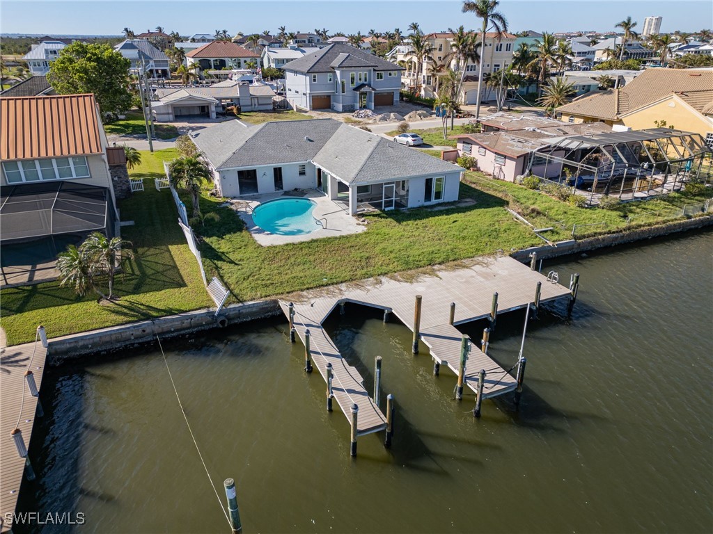 an aerial view of a house with swimming pool and outdoor seating