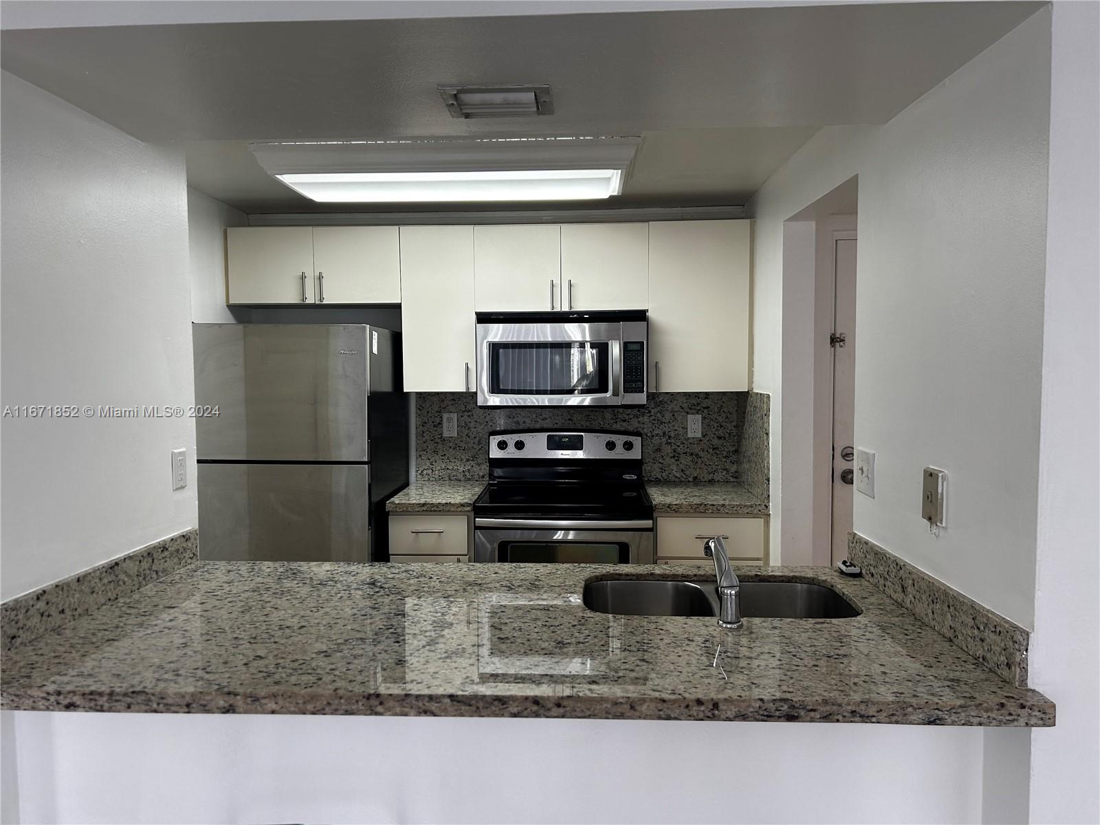 a kitchen with kitchen island a counter space and a sink