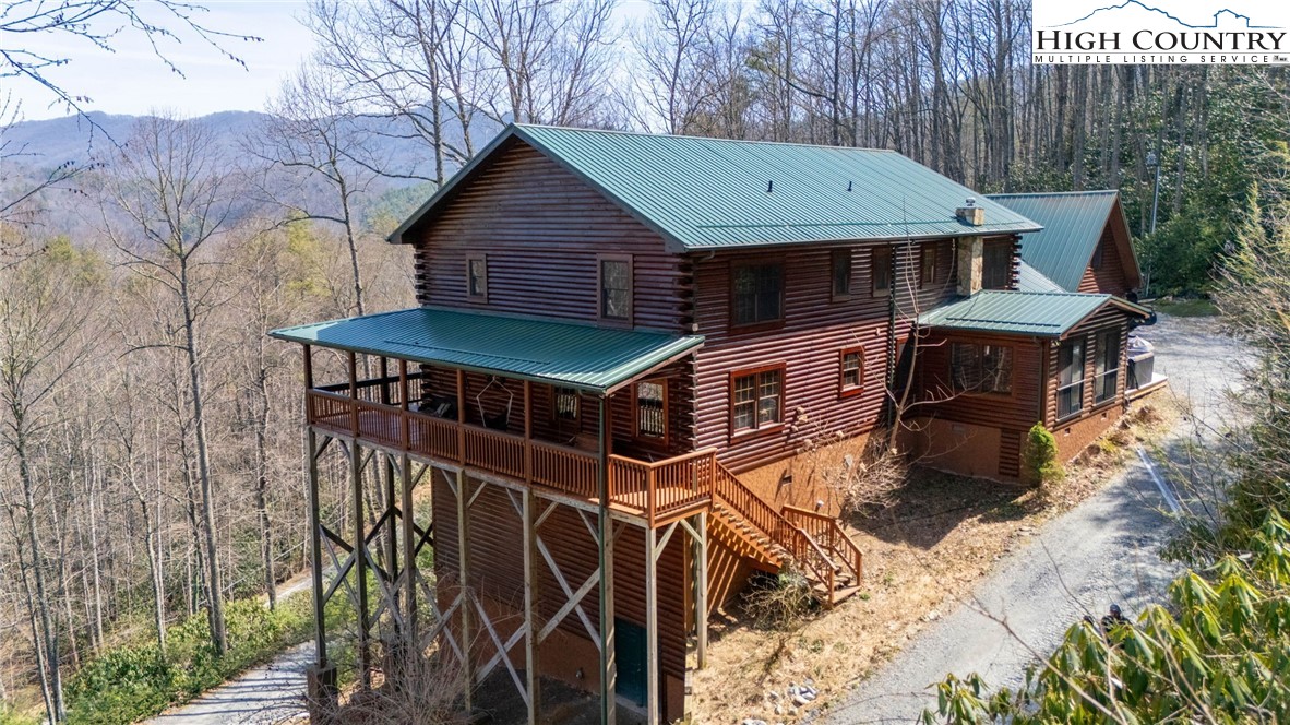 a view of a house with wooden fence next to a yard