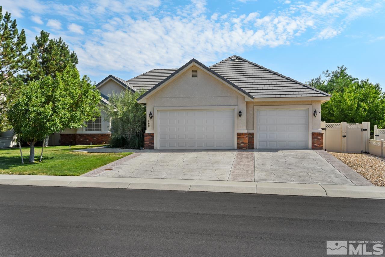 a front view of house with garage and trees