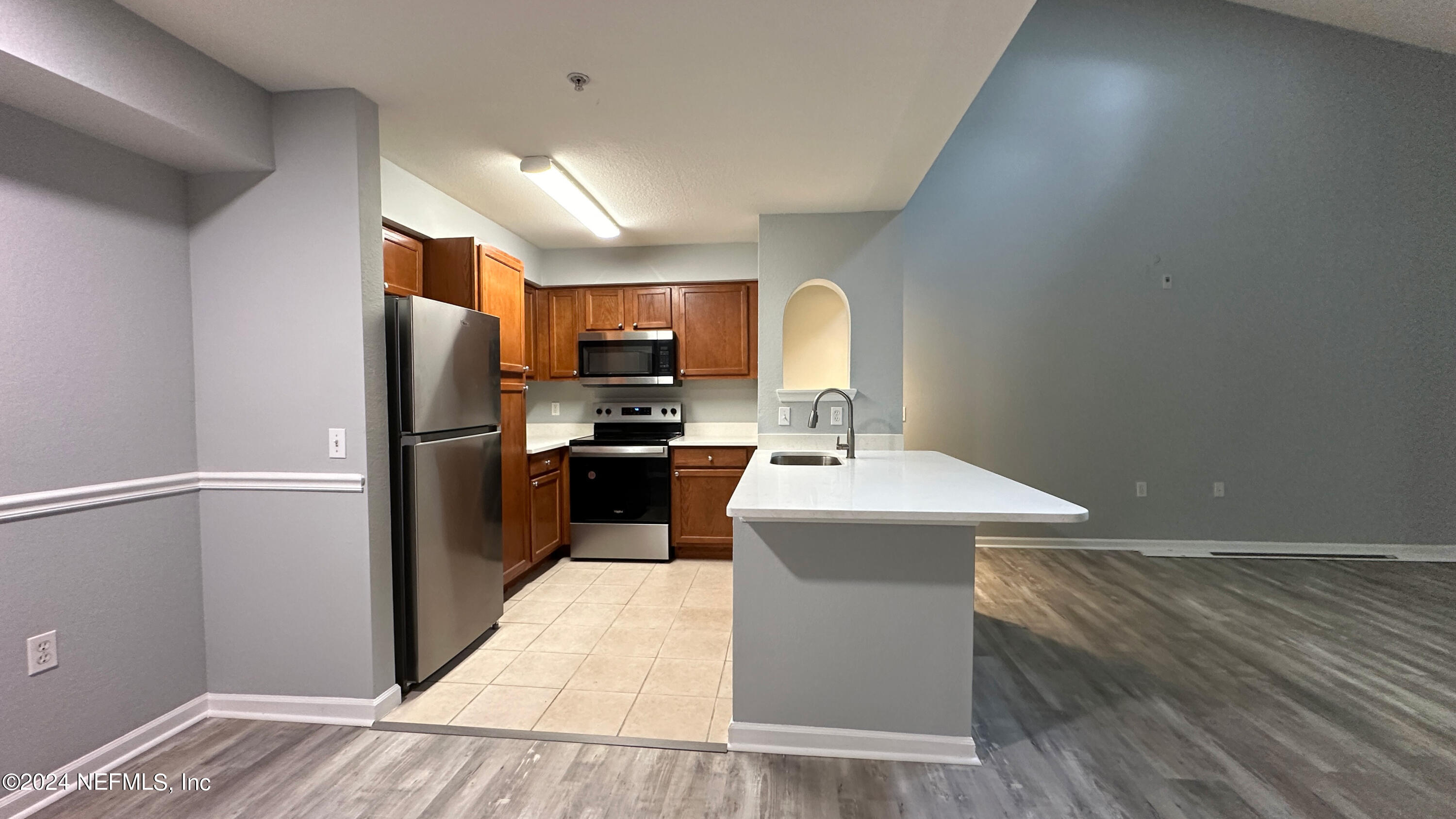 a kitchen with kitchen island a sink stainless steel appliances and cabinets