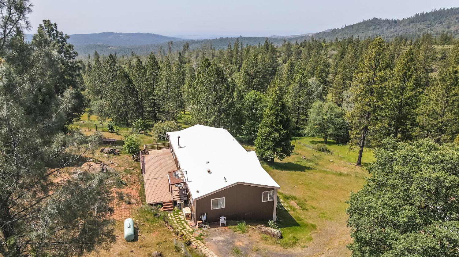 an aerial view of a house with a yard and trees in the back