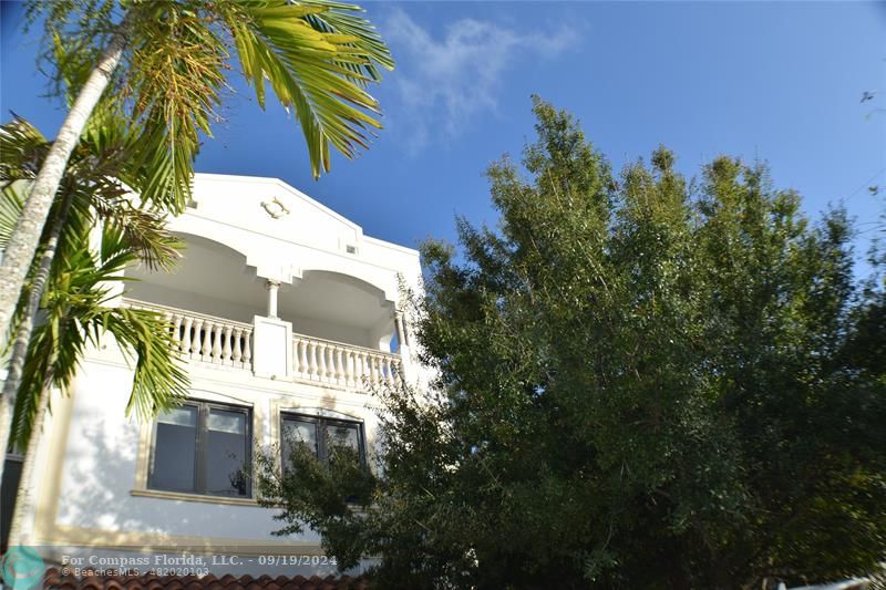 a view of a house with a yard and potted plants