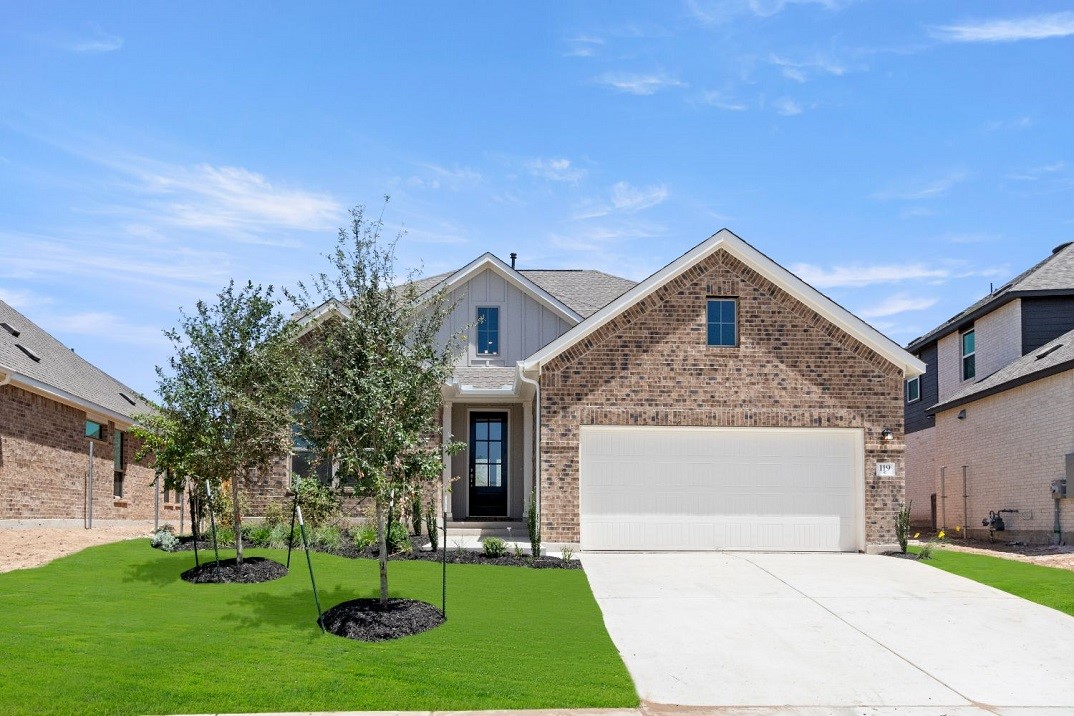 a front view of a house with a yard and garage