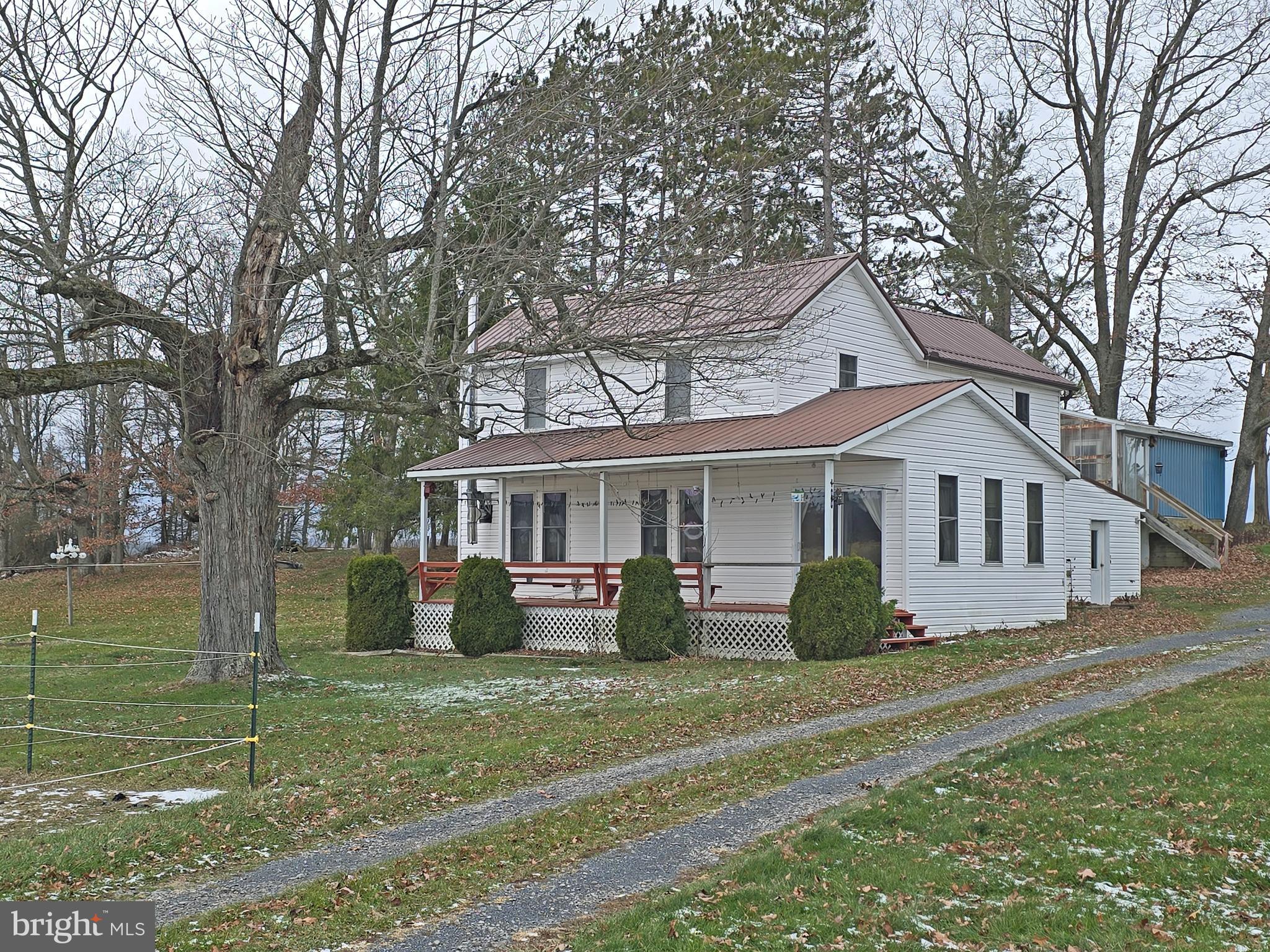 a front view of a house with a garden and trees