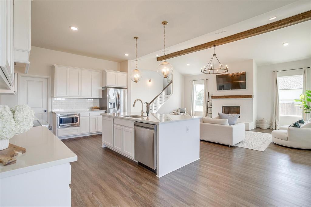 a open kitchen with white cabinets and white appliances