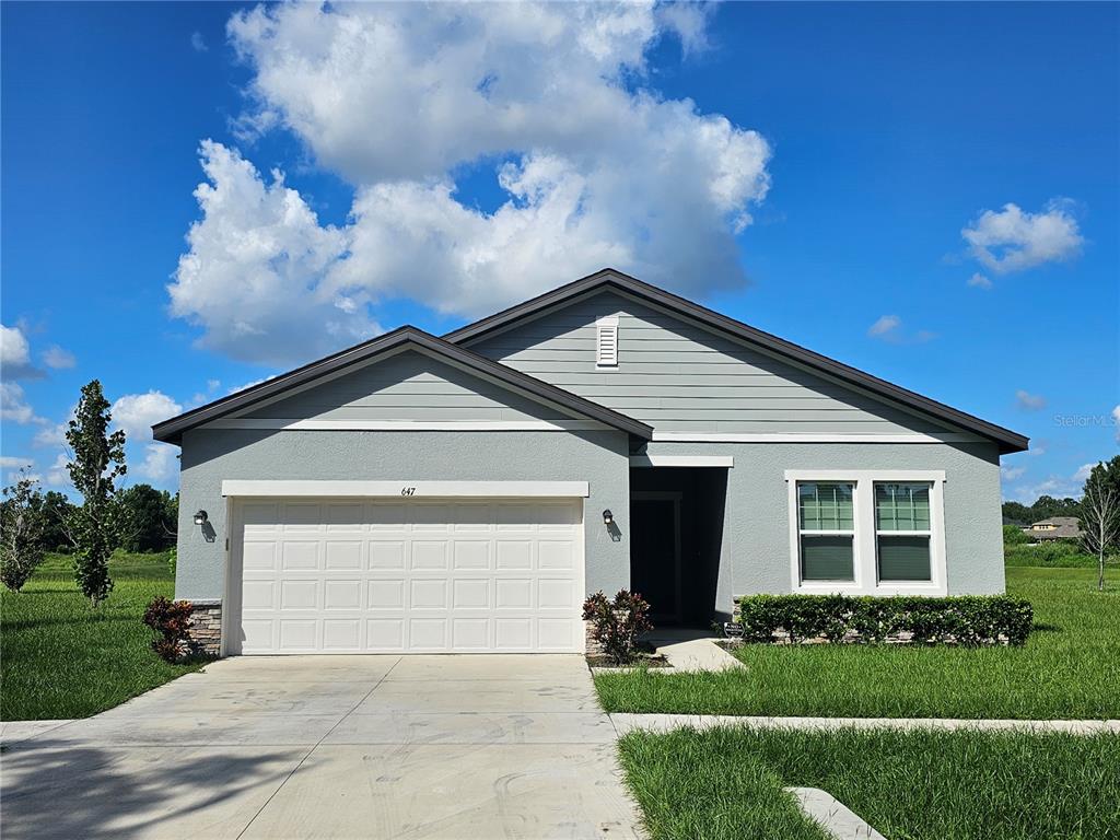 a front view of a house with a yard and garage