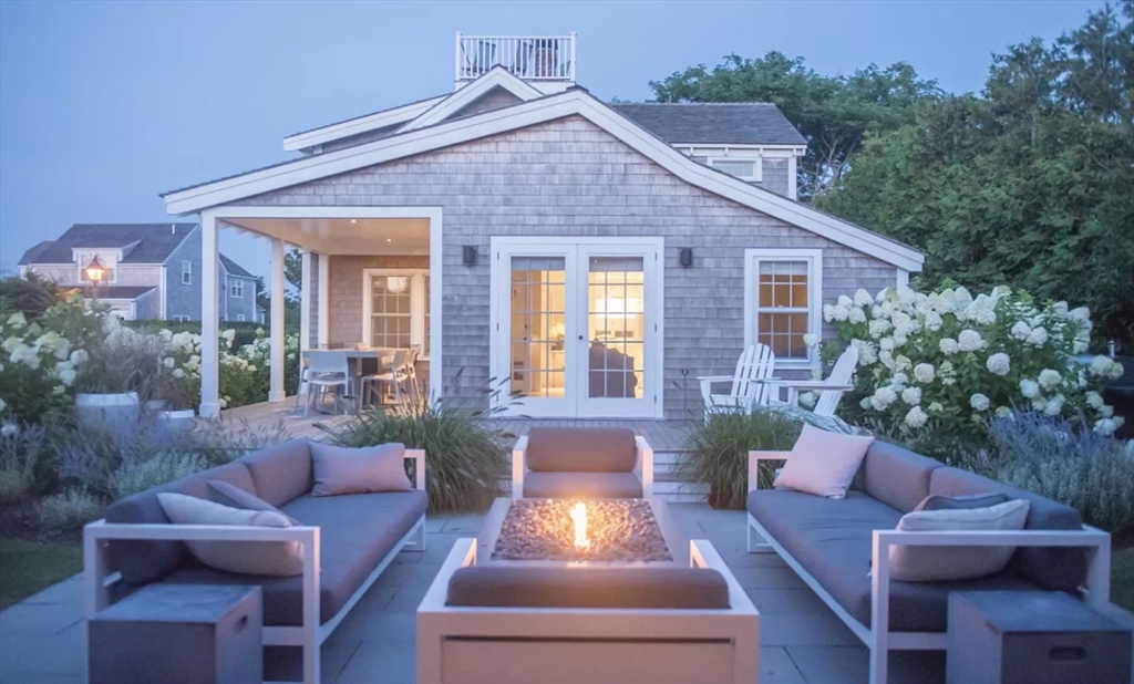 a view of a patio with couches table and chairs and potted plants