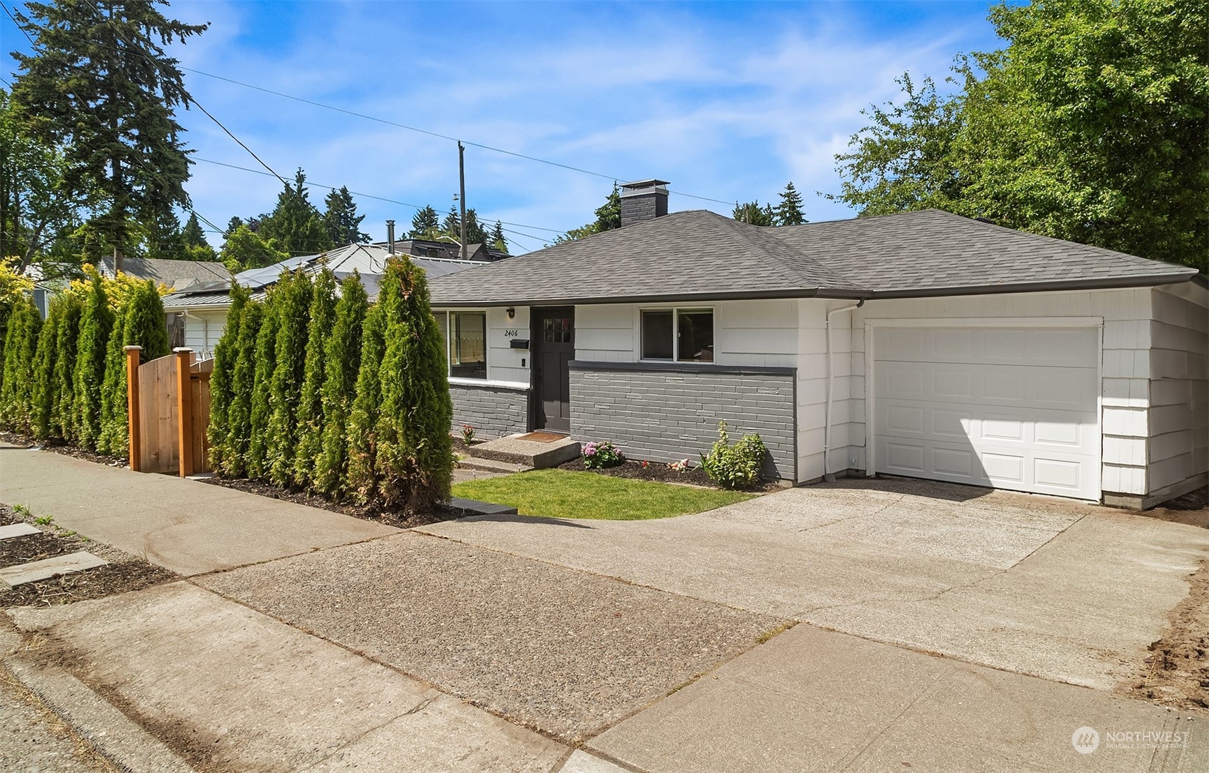 a front view of a house with a yard and trees