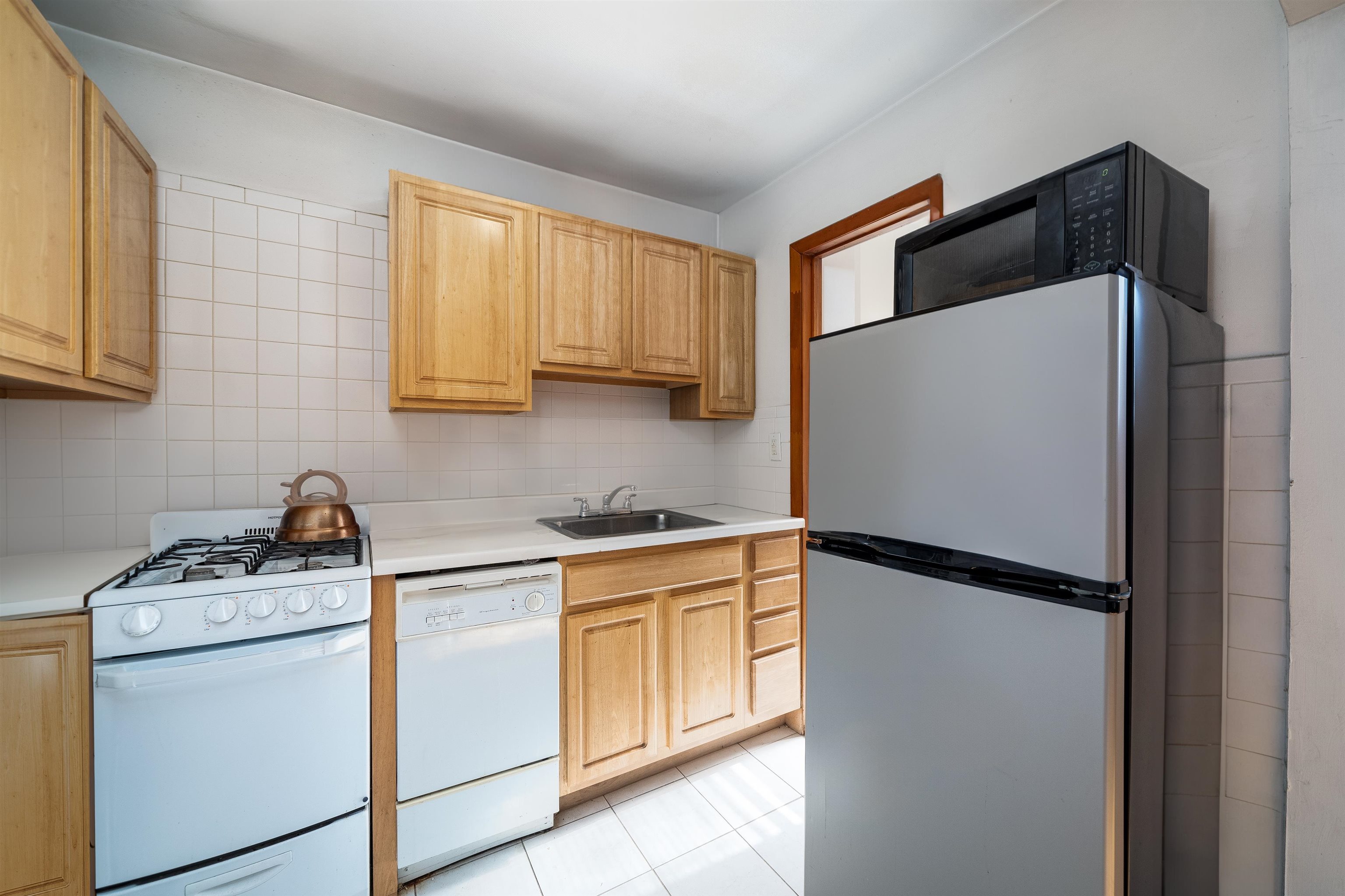 a kitchen with a refrigerator sink stove and cabinets