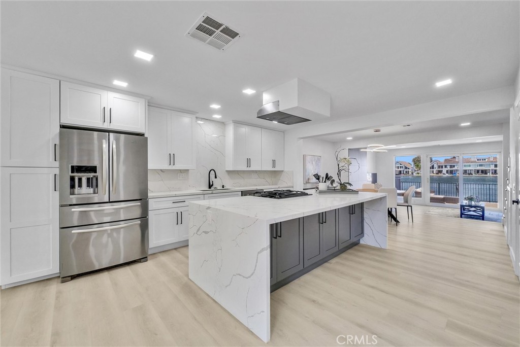 a large kitchen with stainless steel appliances lots of counter space and wooden floor