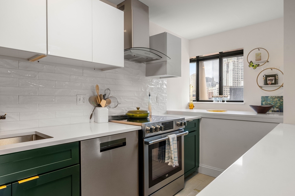 a kitchen with stainless steel appliances granite countertop a sink a stove and cabinets