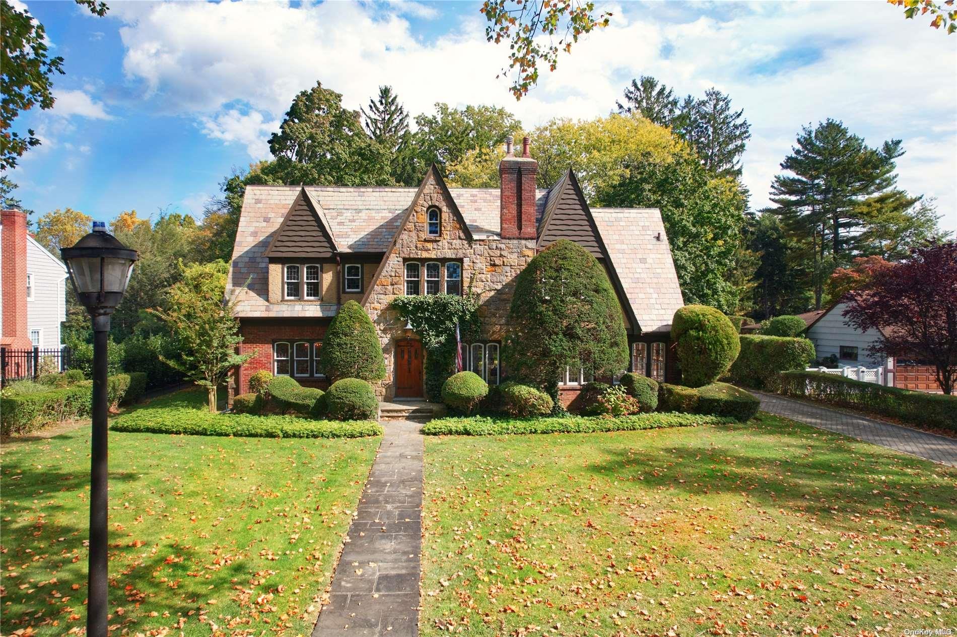 a view of a house with a big yard potted plants and large tree