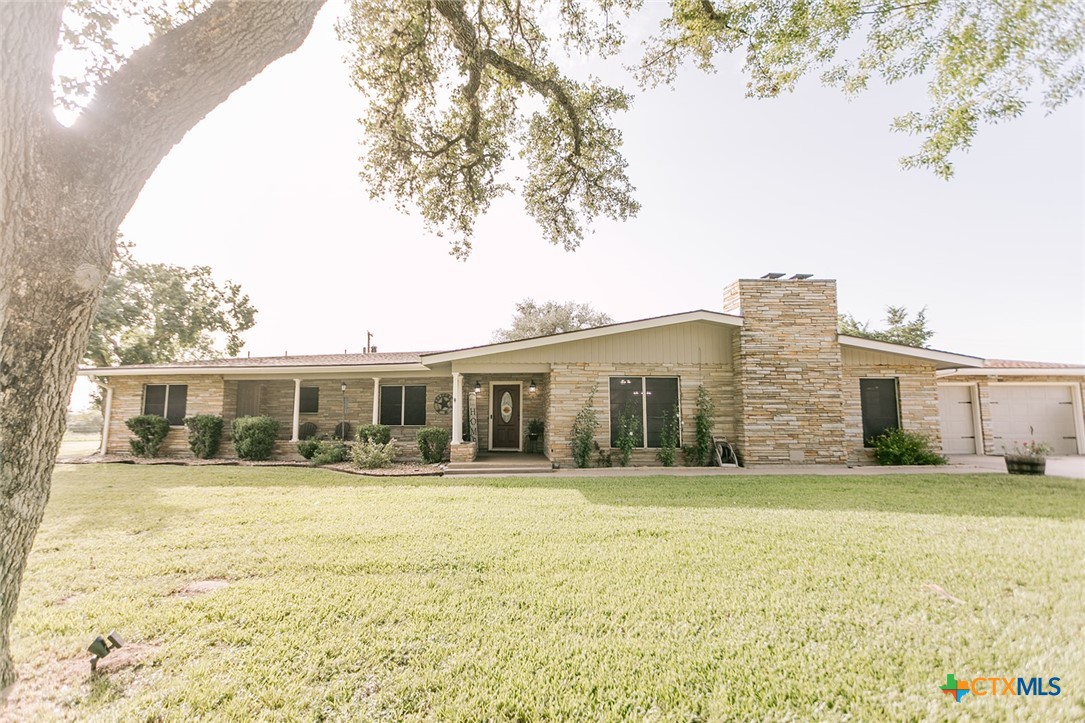 a front view of house with yard and trees around