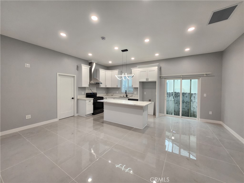 a large kitchen with kitchen island a sink a center island stainless steel appliances and a cabinets