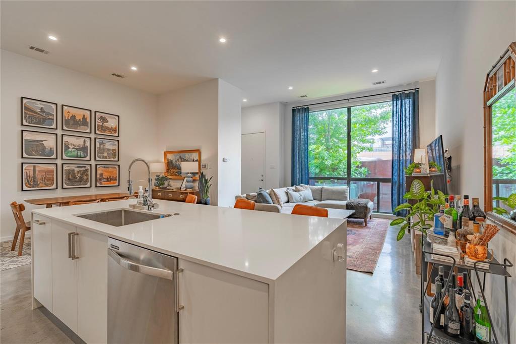 a kitchen that has a lot of cabinets a sink and wooden floor