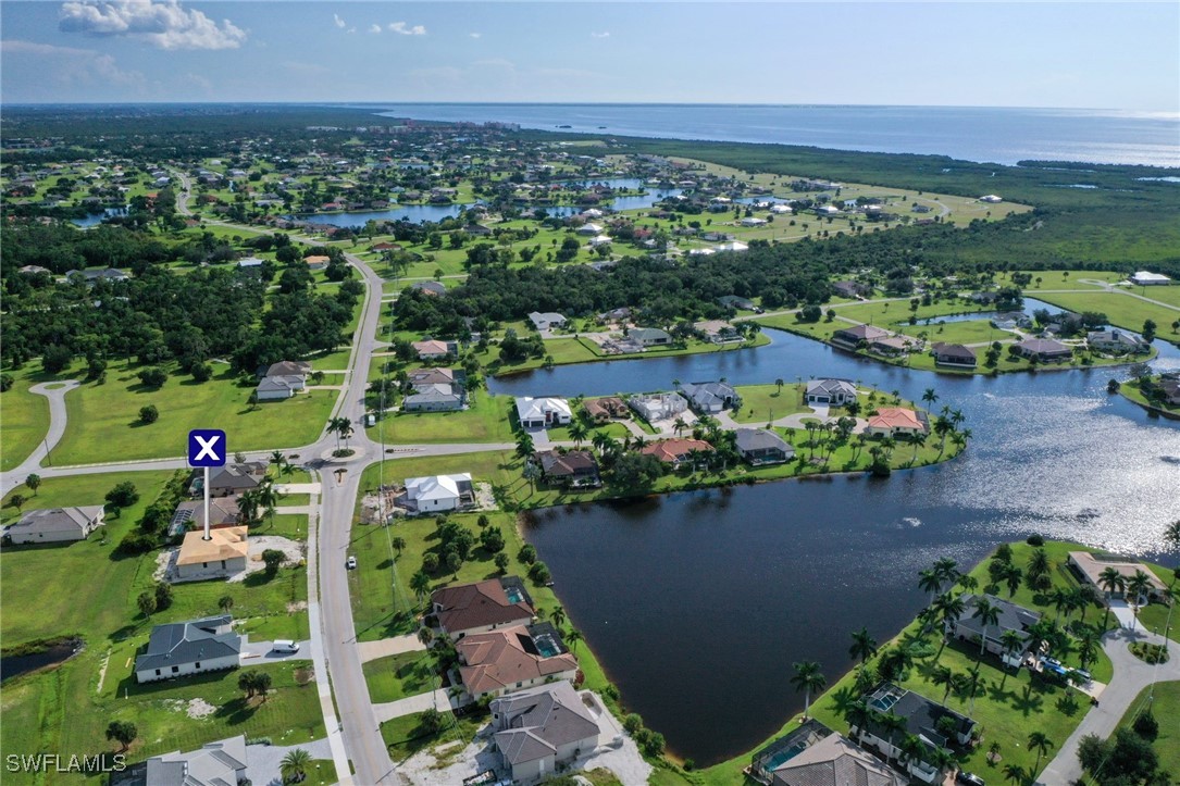 an aerial view of a houses with a garden and lake view