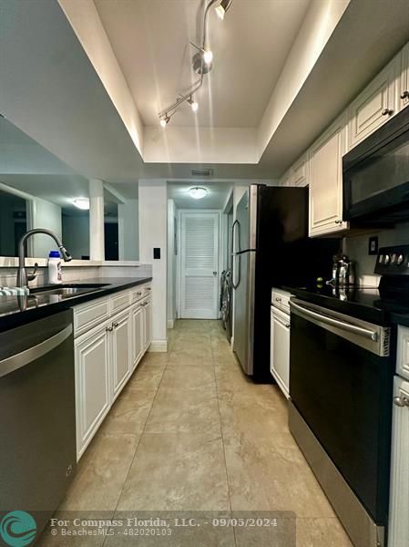 a kitchen with a sink stainless steel appliances and cabinets