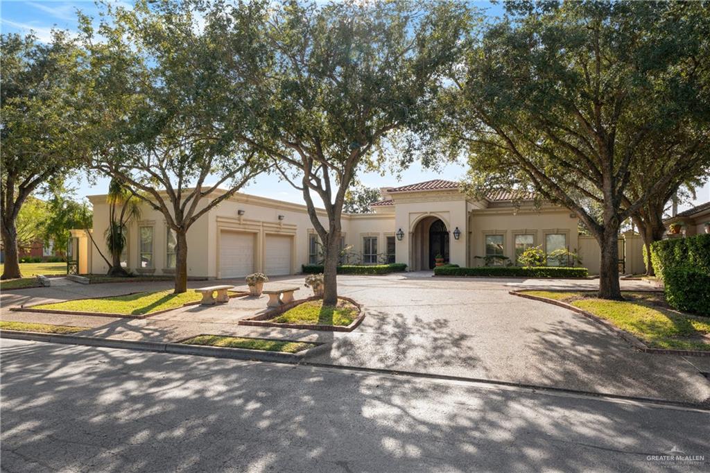 a white house with a large tree next to a yard