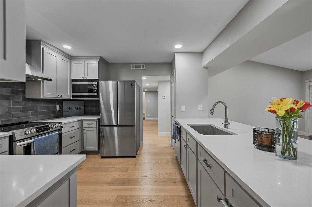 a kitchen with stainless steel appliances granite countertop a sink stove and refrigerator