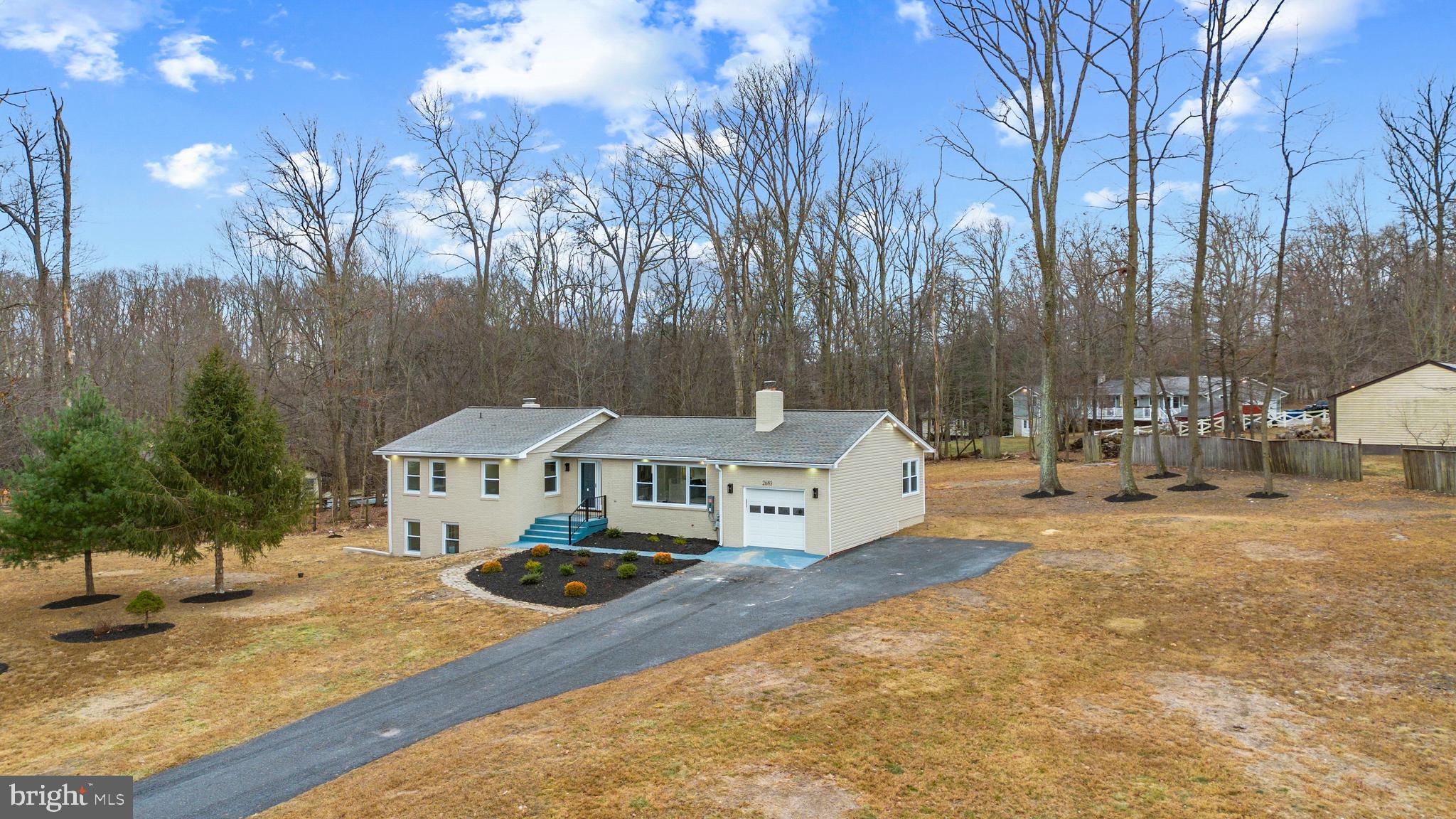 a view of a house with yard and trees in the background