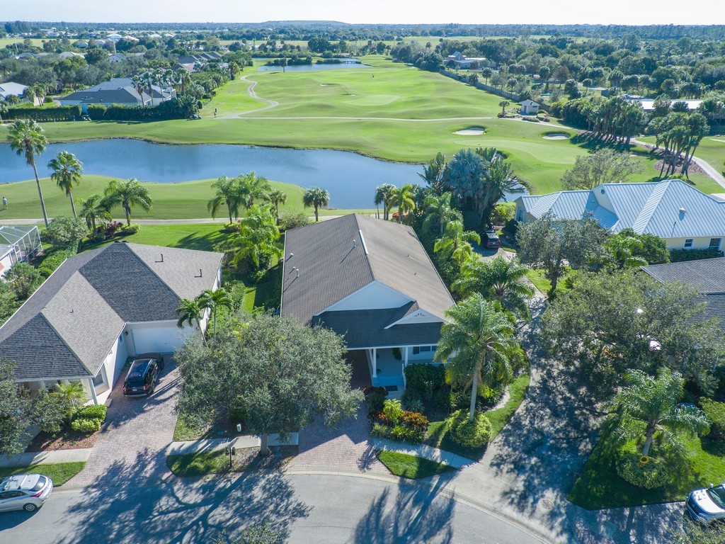 an aerial view of a house with a garden and lake view