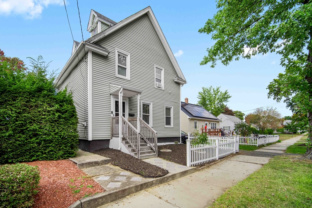 a view of a house with a yard and potted plants