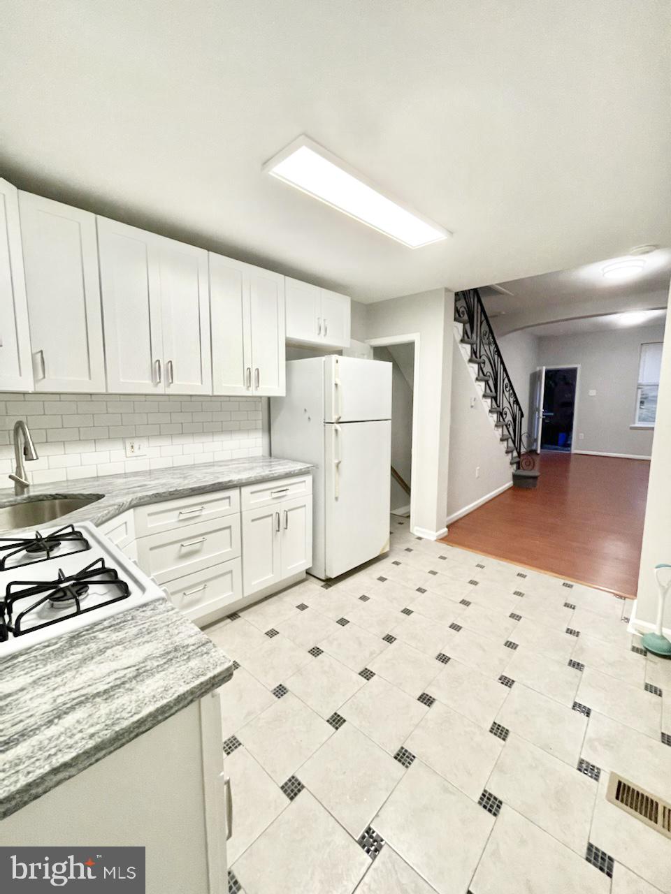 a kitchen with a stove a refrigerator and cabinets