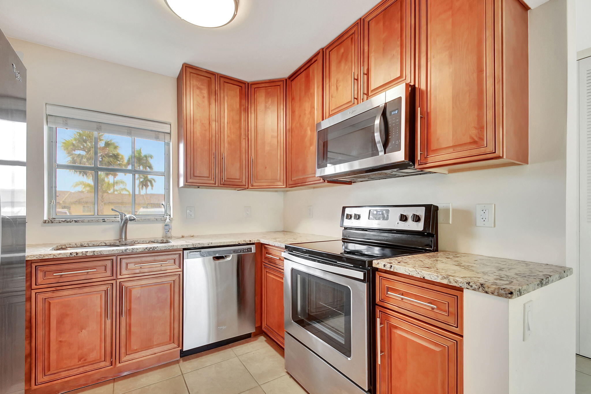 a kitchen with granite countertop cabinets stainless steel appliances and a sink