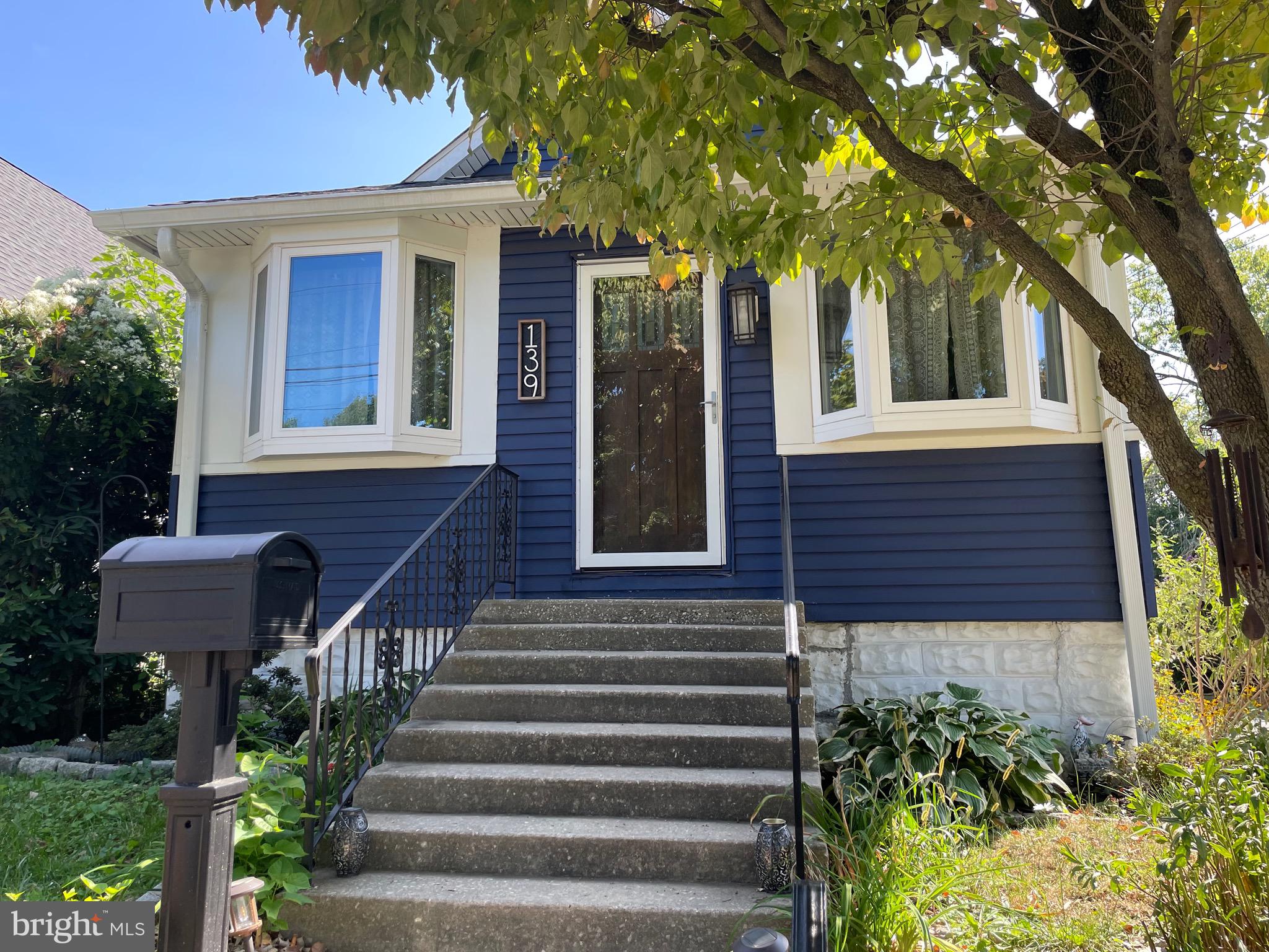 a front view of a house with plants and garden