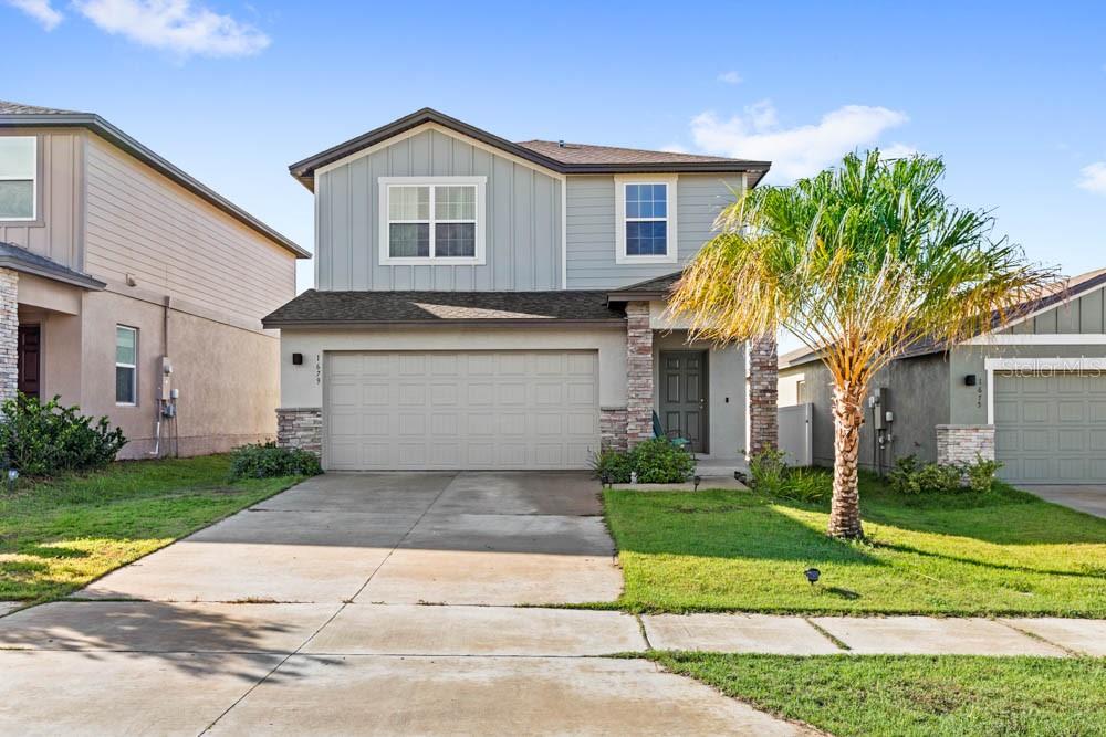 a front view of a house with a yard and garage