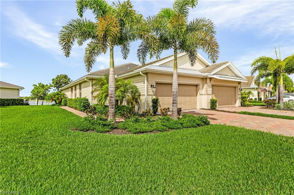 View of front facade featuring a garage and a front lawn