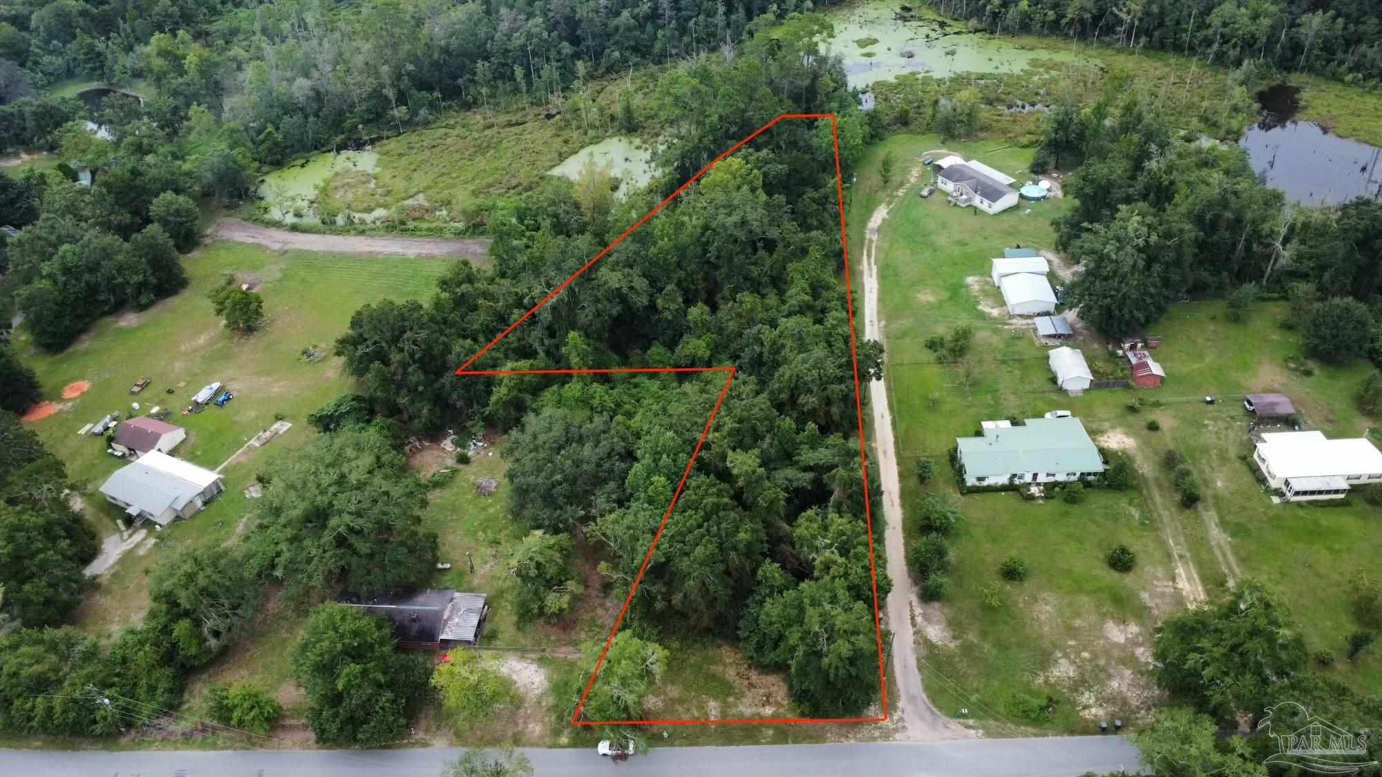 an aerial view of residential houses with outdoor space and trees