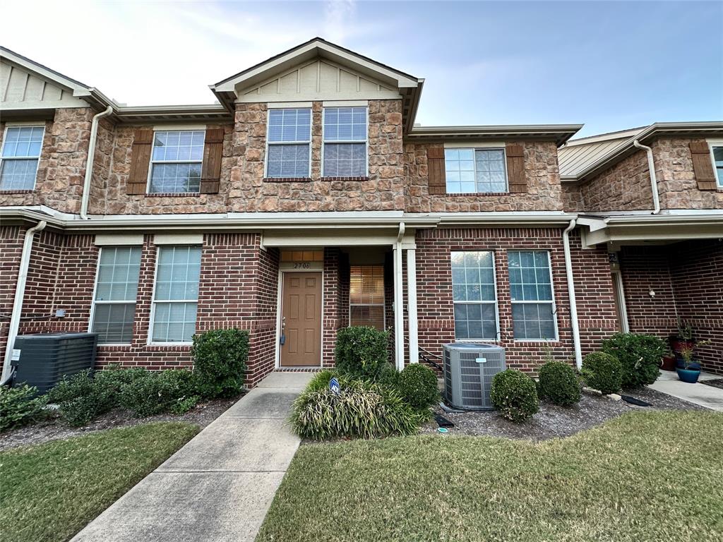 front view of a brick house with a yard