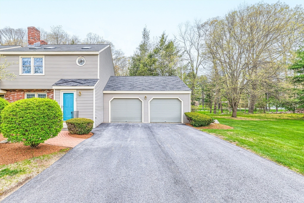 front view of a house with a yard and an trees