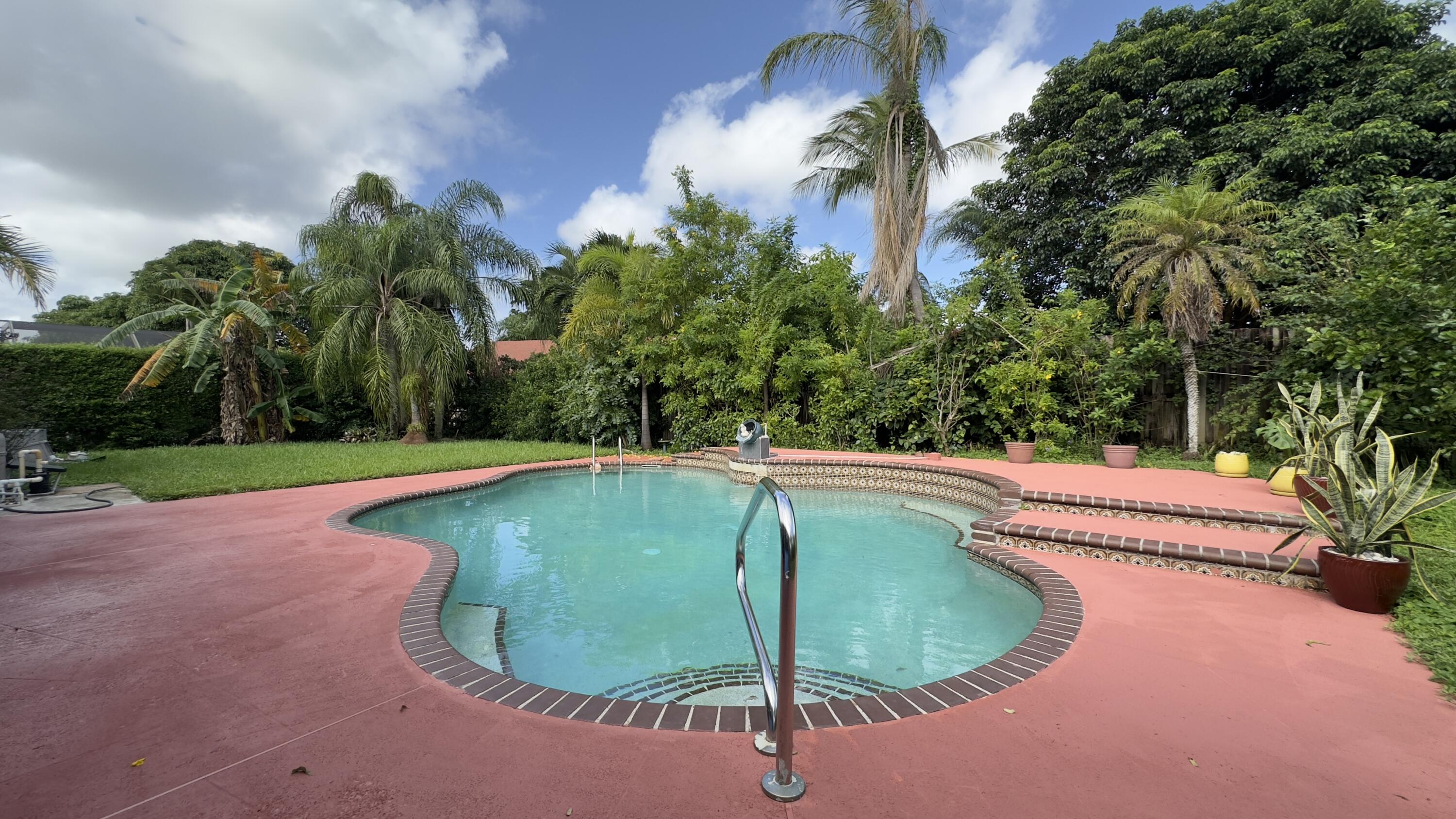 a view of a swimming pool with a yard in front of it