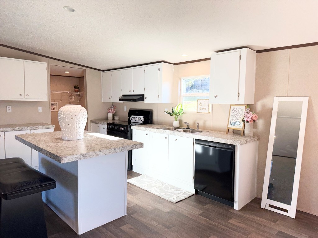 a kitchen with kitchen island granite countertop a sink appliances and cabinets