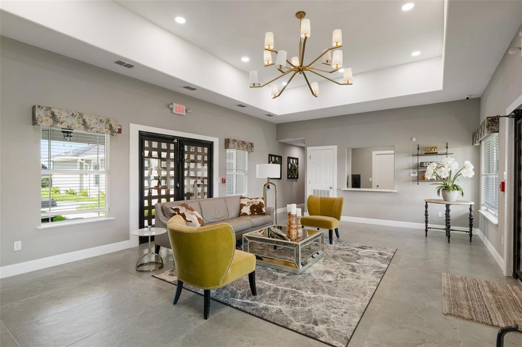 a living room with furniture a chandelier and a window