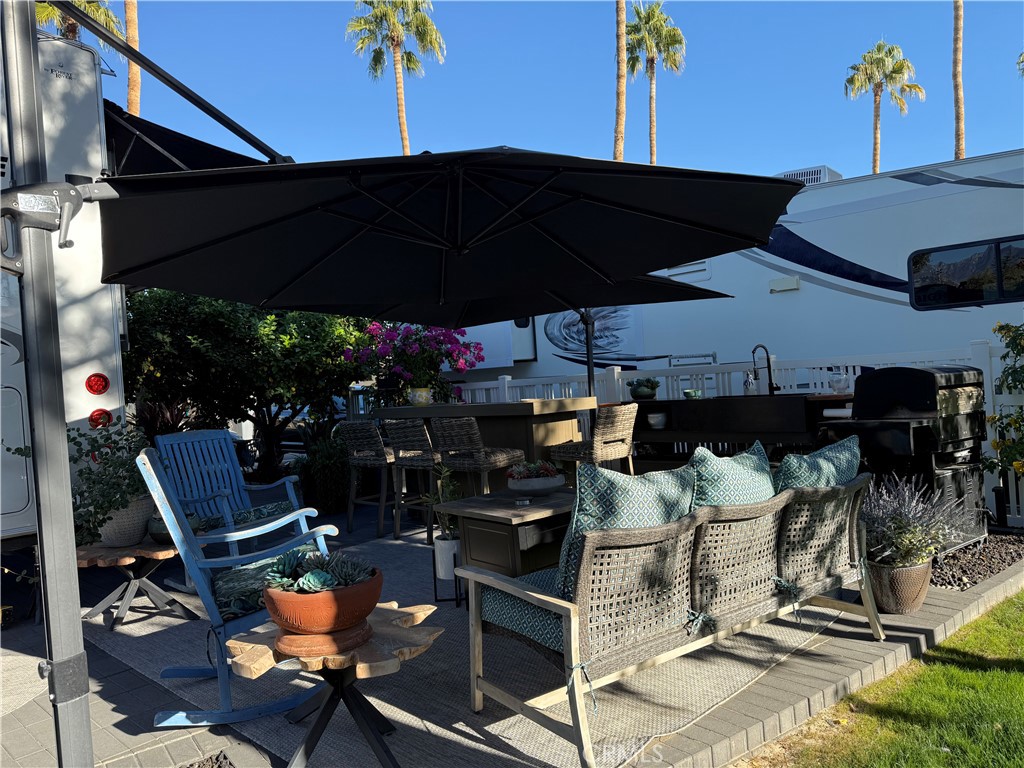 a view of a patio with table and chairs under an umbrella