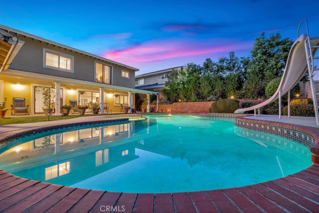 a view of a swimming pool with a deck and a backyard