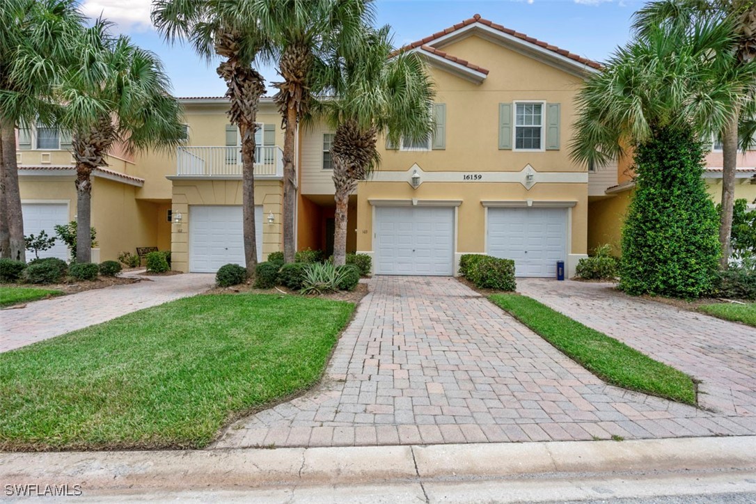 a front view of a house with a yard and trees