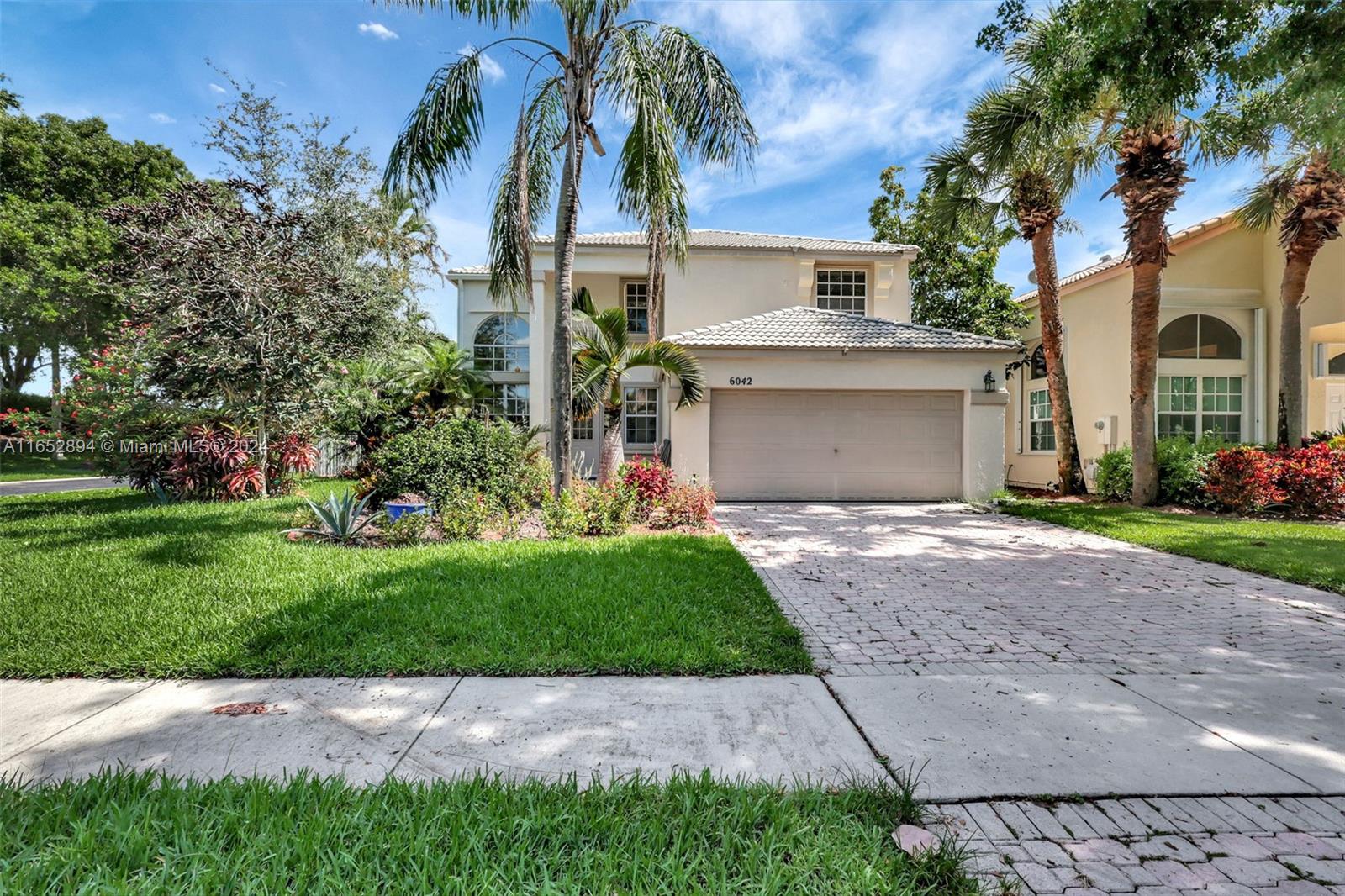 a view of a house with a yard and palm trees