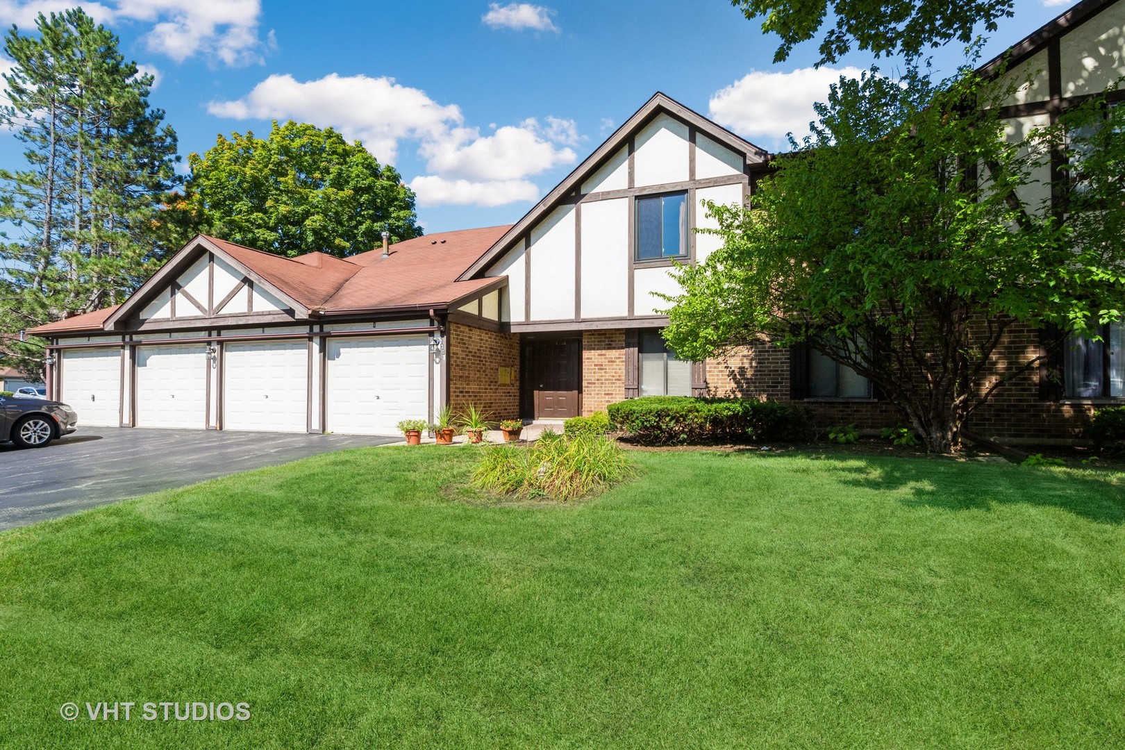 a front view of a house with a yard and trees