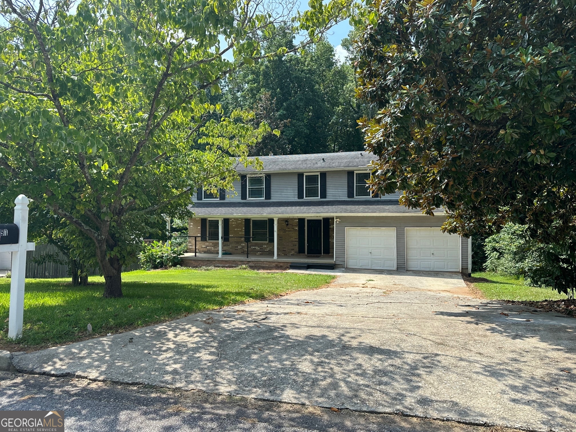 a front view of a house with a yard and trees