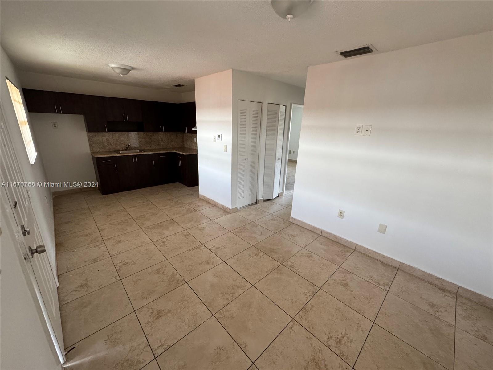 a view of kitchen with refrigerator and cabinets