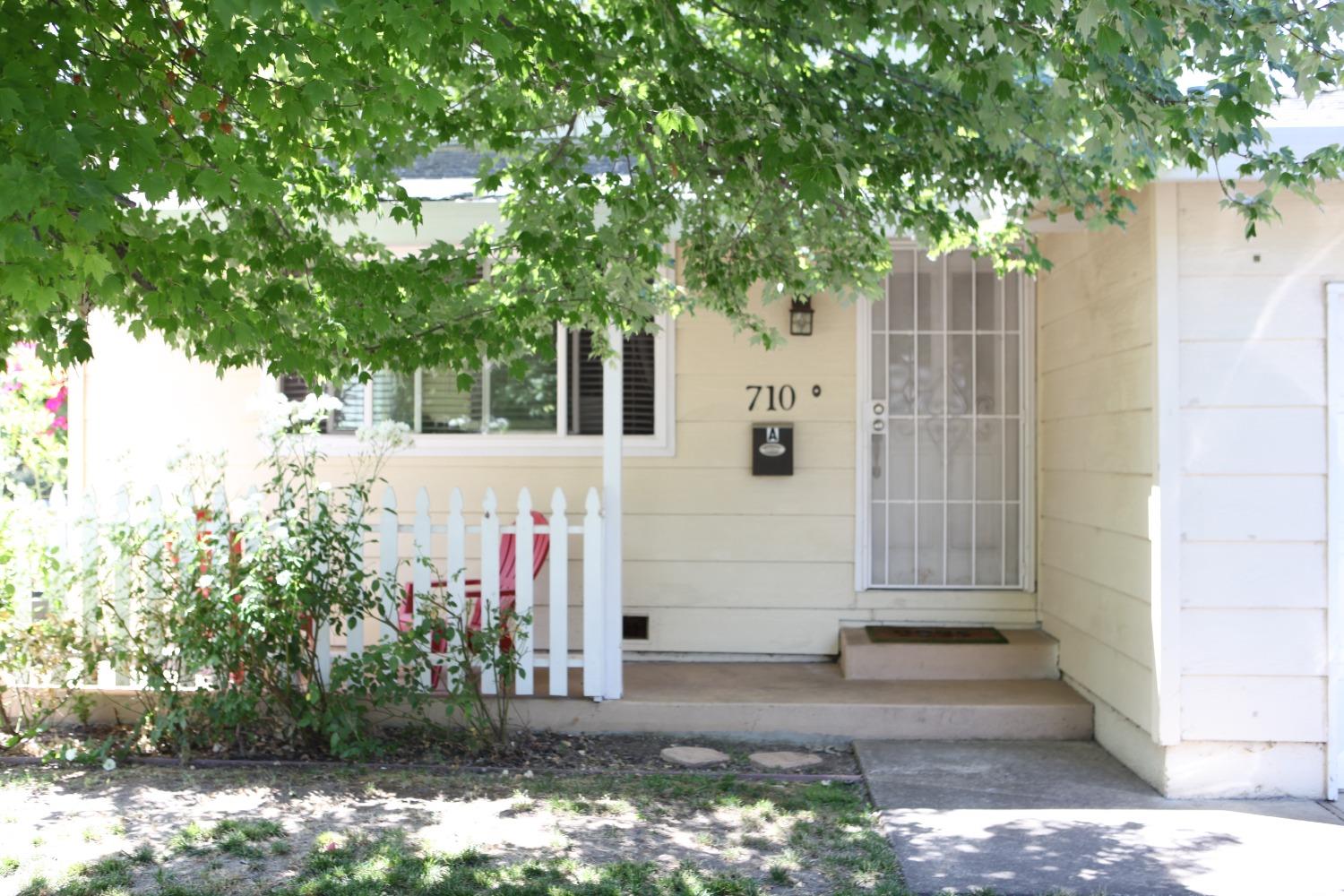 a front view of a house with a tree